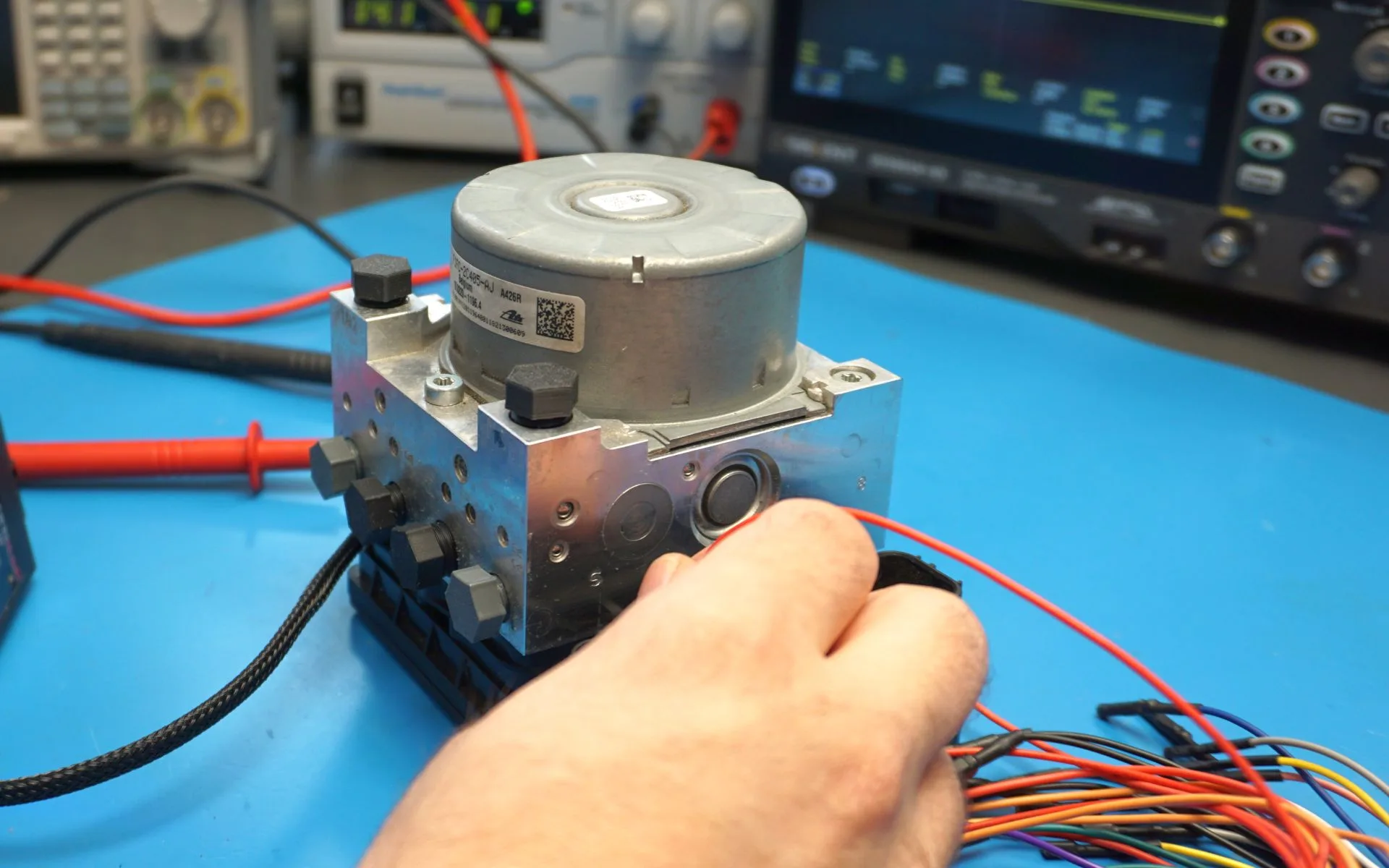 Techniker führt eine ATE MK100 Reparatur durch und pinnt den ABS Hydraulikblock zur elektrischen Prüfung an